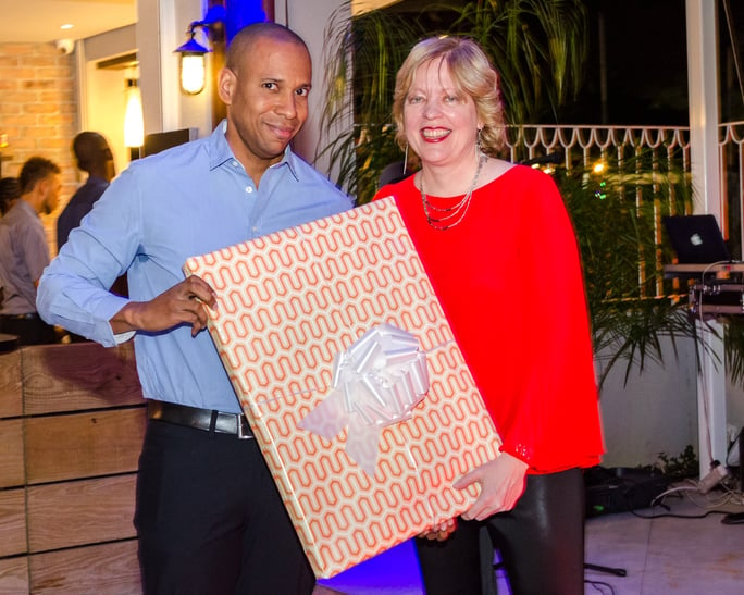 Anya Schnoor, Scotiabank’s Head Caribbean South and East, presents David Noel’s farewell gift - original artwork from his favorite artist
